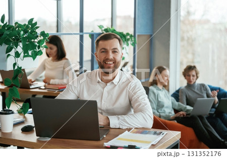 Sitting by laptops. People are working in the office with bean bags chairs in it Sitting by laptops. People are working in the office with bean bags chairs in it 131352176