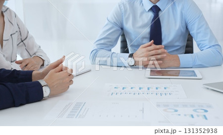 Business people reviewing financial metrics on digital screens, collaborating strategically while examining charts and graphs in office 131352938