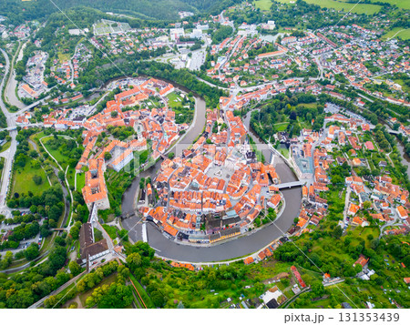 A breathtaking aerial perspective of Cesky Krumlov reveals its charming old town, historic castle, and winding Vltava River, all bathed in the soft light of morning. 131353439