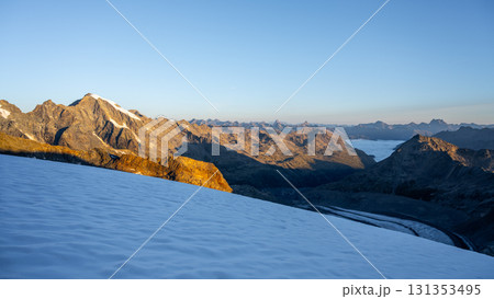 The sun rises over Pers Glacier, illuminating the ice and mountains of the Bernina Range. A serene morning in the Swiss Alps reveals the stunning landscape of Graubunden. 131353495