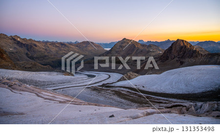 Early morning reveals the stunning beauty of Pers Glacier in the Bernina Range. The sun rises over the majestic peaks, casting soft hues across the rugged alpine landscape. 131353498