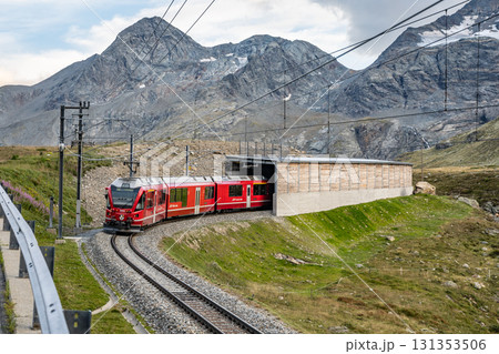 The Bernina railway winds through the breathtaking Swiss Alps near Bernina Pass, showcasing stunning mountain views and lush greenery in Graubunden. The Bernina railway winds through the breathtaking Swiss Alps near Bernina Pass, showcasing stunning mountain views and lush greenery in Graubunden. 131353506