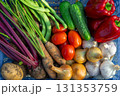Diverse fresh garden vegetablestomatoes, cucumbers, peppers, carrots, beets, green beans, onions, garlic and potatoesneatly arranged in a blue crate, seasonal harvest and healthy eating 131353759