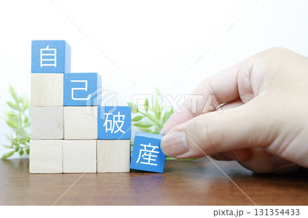 自己破産イメージ。積み木と白背景のコピースペースありの広告素材。 自己破産イメージ。積み木と白背景のコピースペースありの広告素材。 131354433