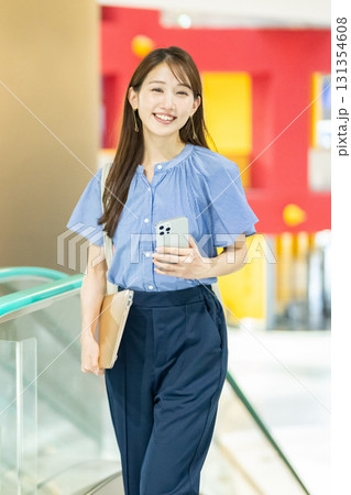 エスカレーターに乗るビジネスウーマン 131354608