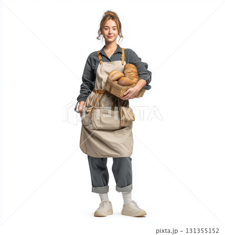 パン屋の制服にエプロンを重ねた若い女性が店内でパンを運ぶ姿を切り取った可愛い雰囲気 131355152