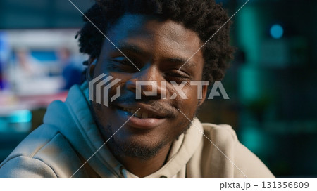 African American adult enjoying the comfort of his loft apartment while working remotely on his laptop. An excellent representation of productivity and modern work from home trends. Camera A. 131356809