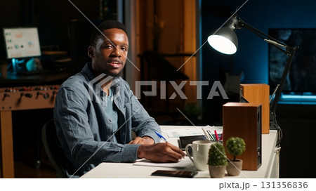 POV of african american guy attending an online conference from his home office in loft. Male speaker discussing work remotely with coworkers using wireless tech for video call. Camera B. POV of african american guy attending an online conference from his home office in loft. Male speaker discussing work remotely with coworkers using wireless tech for video call. Camera B. 131356836