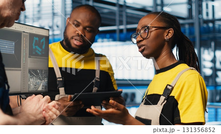 Photovoltaics smart factory elderly team leader talks with workers diagnosing damaged IoT sensors. Industry 4.0 solar panels plant senior engineer and employees work to reduce downtime, camera A 131356852