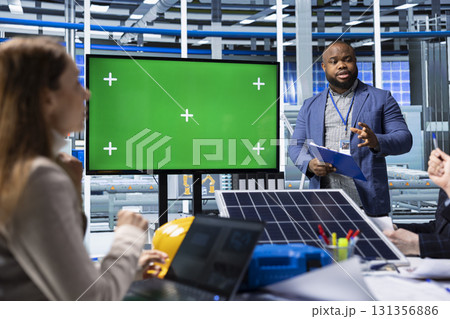 Solar panels manufacturing plant managers holding meeting using chroma key display. Photovoltaics factory management taking notes of upgrades to make using green screen monitor 131356886