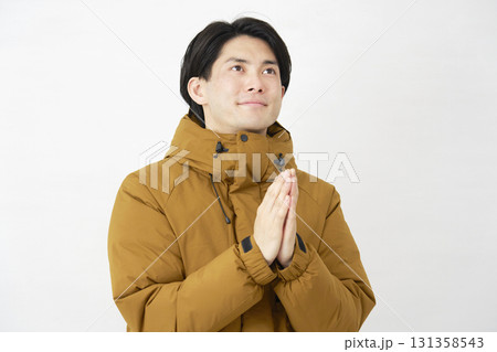 ダウンジャケットを着た男性 合掌して祈る 白背景 ダウンジャケットを着た男性 合掌して祈る 白背景 131358543