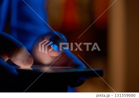 Hand using smartphone in dark room 131359080