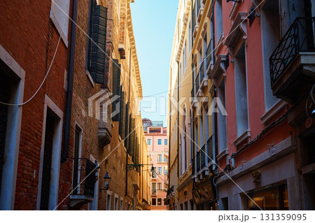 Narrow street between historic buildings in Venice 131359095