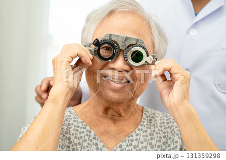 Asian senior woman wearing ophthalmic vision eye test and using optical trial frame. Asian senior woman wearing ophthalmic vision eye test and using optical trial frame. 131359298