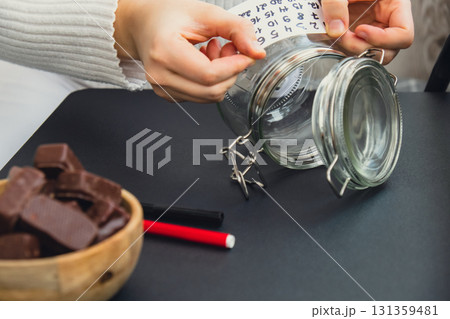 Original Advent Calendar made of glass jar and sweet chocolate candies Christmas concept. Countdown till winter holidays. Handmade advent calendar. Step by step DIY Original Advent Calendar made of glass jar and sweet chocolate candies Christmas concept. Countdown till winter holidays. Handmade advent calendar. Step by step DIY 131359481