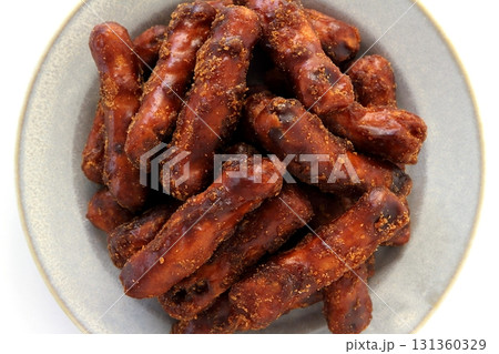 真上から見た白背景の皿に盛った黒糖かりんとう(黒かりんとう) 真上から見た白背景の皿に盛った黒糖かりんとう(黒かりんとう) 131360329