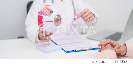 Elderly Patient consulting Doctor to Eye disease, Senior Medical Diagnosis. Anatomy Eye model for Cataract, Glaucoma, Age Related Macular Degeneration, Diabetic Retinopathy, Vitreous, health concept 131360583