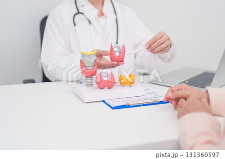 Elderly Patient consulting and Diagnosis with Doctor to Thyroid disease. Anatomy Thyroid model for Hyperthyroidism, Hypothyroidism, Hashimoto Thyroiditis, Thyroid Tumor and Cancer, Papillary Carcinoma Elderly Patient consulting and Diagnosis with Doctor to Thyroid disease. Anatomy Thyroid model for Hyperthyroidism, Hypothyroidism, Hashimoto Thyroiditis, Thyroid Tumor and Cancer, Papillary Carcinoma 131360597