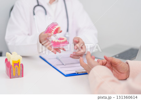 Elderly Patient consulting Dentist to Tooth disease, Senior Health Medical Diagnosis. Anatomy teeth model for Oral Teeth decay, Scrape off tartar. March Oral health, Dentist Day, False Teeth concept 131360614