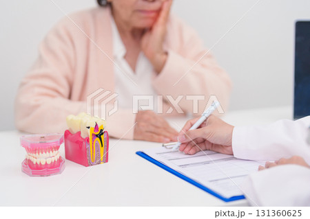 Elderly Patient consulting Dentist to Tooth disease, Senior Health Medical Diagnosis. Anatomy teeth model for Oral Teeth decay, Scrape off tartar. March Oral health, Dentist Day, False Teeth concept Elderly Patient consulting Dentist to Tooth disease, Senior Health Medical Diagnosis. Anatomy teeth model for Oral Teeth decay, Scrape off tartar. March Oral health, Dentist Day, False Teeth concept 131360625