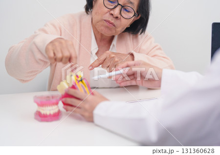 Elderly Patient consulting Dentist to Tooth disease, Senior Health Medical Diagnosis. Anatomy teeth model for Oral Teeth decay, Scrape off tartar. March Oral health, Dentist Day, False Teeth concept Elderly Patient consulting Dentist to Tooth disease, Senior Health Medical Diagnosis. Anatomy teeth model for Oral Teeth decay, Scrape off tartar. March Oral health, Dentist Day, False Teeth concept 131360628