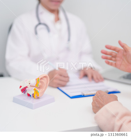 Elderly Patient consulting Doctor to Ear disease. Senior Health Medical Diagnosis. Anatomy Ear model for Atresia, Otitis Media, Pertorated Eardrum, Meniere syndrome, otolaryngologist, Hearing Loss Elderly Patient consulting Doctor to Ear disease. Senior Health Medical Diagnosis. Anatomy Ear model for Atresia, Otitis Media, Pertorated Eardrum, Meniere syndrome, otolaryngologist, Hearing Loss 131360661