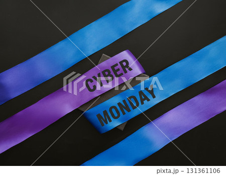 Cyber Monday text on purple and blue satin ribbons with black background, minimalistic holiday shopping banner concept for ecommerce, retail sales and online digital marketing promotions 131361106