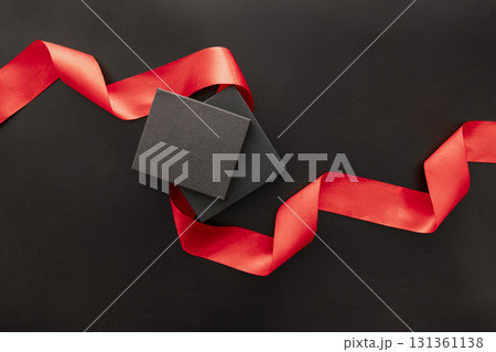 Two black gift boxes with a red ribbon on a black background. Ideal for Black Friday sale promotions and holiday shopping themes. 131361138