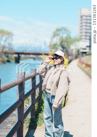 Woman tourist sightseeing Iwate mountain and Kitakami river with flowers in Spring, happy traveler travel in Morioka city, Iwate prefecture, Japan. famous Landmark Travel and Vacation destination Woman tourist sightseeing Iwate mountain and Kitakami river with flowers in Spring, happy traveler travel in Morioka city, Iwate prefecture, Japan. famous Landmark Travel and Vacation destination 131361263