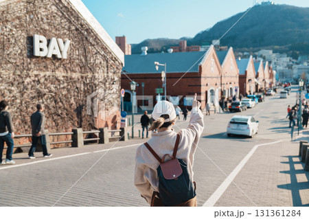 Woman tourist Visiting in Hakodate, happy Traveler sightseeing Kanemori Red Brick Warehouse in spring season. landmark and popular for attractions in Hokkaido, Japan. Travel and Vacation concept 131361284
