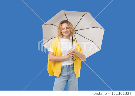 Woman smiles while holding a white umbrella in bright light 131361327