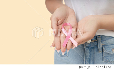 Pink ribbon being held to promote cancer awareness initiatives Pink ribbon being held to promote cancer awareness initiatives 131361478