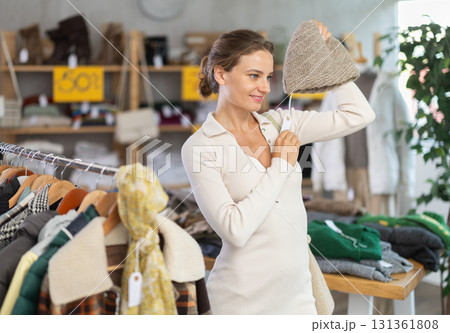 Young woman choosing hat in clothing store 131361808