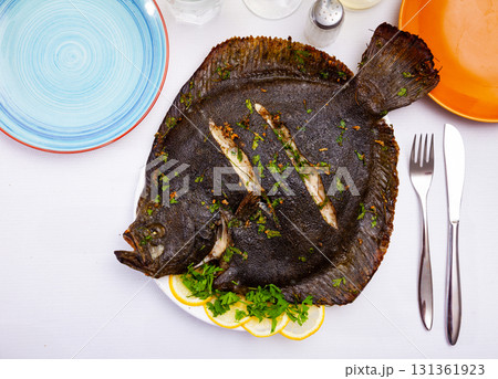 Close view of baked flounder on plate with parsley Close view of baked flounder on plate with parsley 131361923