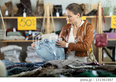Woman choosing jeans in a store Woman choosing jeans in a store 131361987