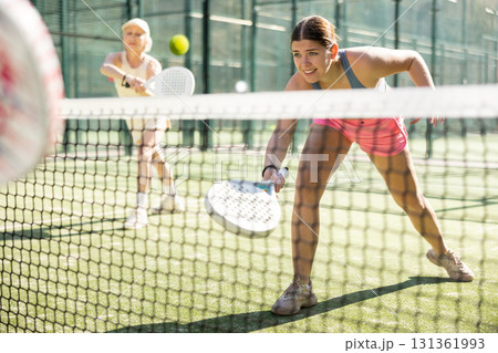 Young woman playing Padel Tennis in open-air tennis court Young woman playing Padel Tennis in open-air tennis court 131361993