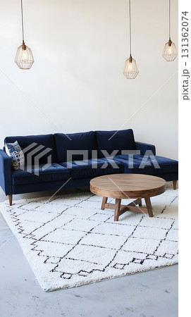 Blue couch is in a room with a white rug and a wooden coffee table 131362074