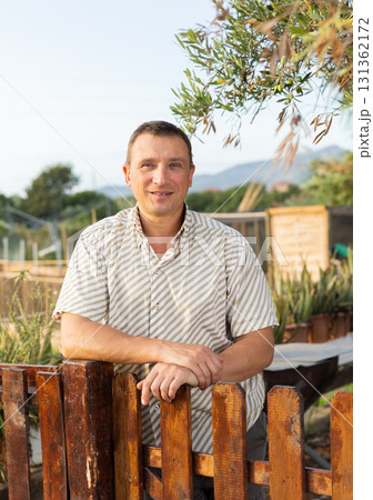 Portrait of positive man at fence 131362172