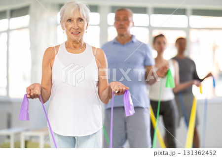 Group Pilates classes for seniors - using resistance bands and expander to stretch entire body Group Pilates classes for seniors - using resistance bands and expander to stretch entire body 131362452