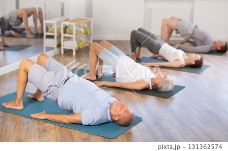 Elderly man doing pilates in group 131362574