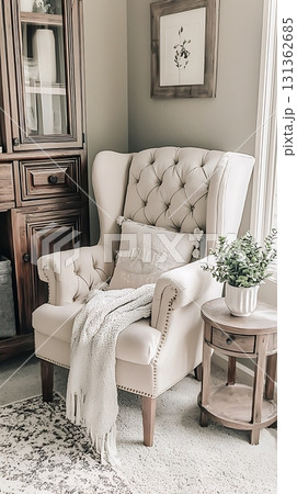 Chair with a white pillow and a blanket on it Chair with a white pillow and a blanket on it 131362685