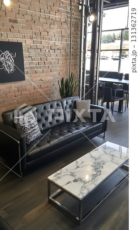 Black couch sits in front of a white marble coffee table 131362719