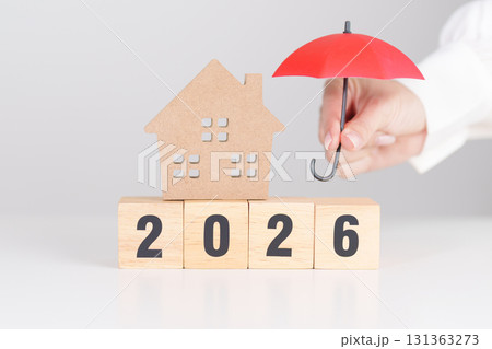 Happy New Year 2026 with red umbrella over money stack. Insurance, real estate, Home loan, tax, investment, mortgage, financial, savings, protection and safety 131363273