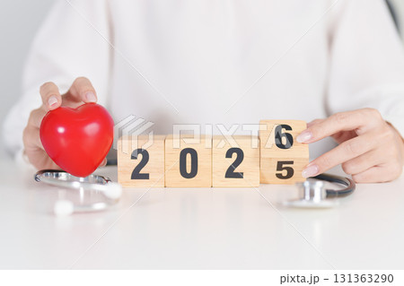 2025 end year to Happy New Year 2026 with Stethoscope of doctor and heart shape on table. health care, Insurance, Wellness and medical concepts 131363290