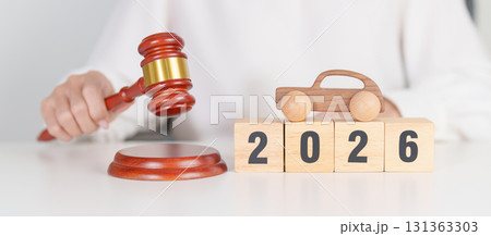 Happy New Year 2026 with small toy car models and Judges gavel on desk in courthouse. Car Law, Insurance, auto Tax, Auction and Bidding concepts 131363303