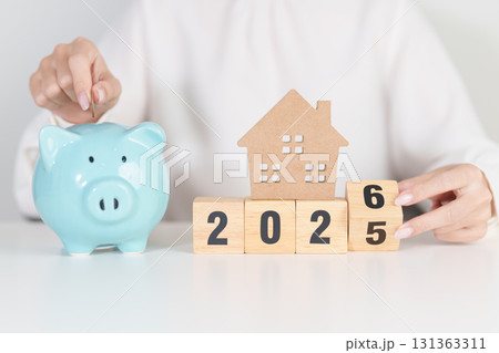 Happy New Year 2026 with house model and Coins stack. real estate, Home loan, tax, investment, mortgage, financial, savings and New Year Resolution concepts 131363311