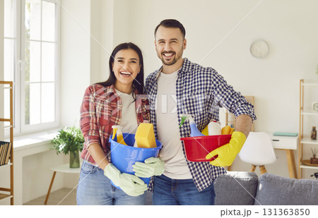 Young happy couple clean, man and woman janitor pair with house cleaning materials 131363850