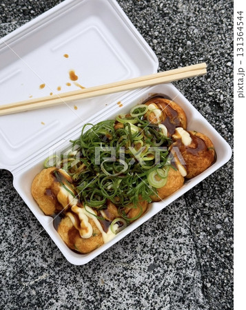 Takoyaki, a popular Japanese street food, are crispy round dough balls filled with octopus, tempura bits, and pickled ginger, topped with takoyaki sauce, bonito flakes, and aonori. Takoyaki, a popular Japanese street food, are crispy round dough balls filled with octopus, tempura bits, and pickled ginger, topped with takoyaki sauce, bonito flakes, and aonori. 131364544