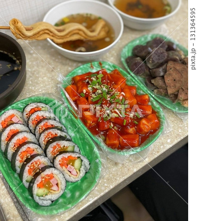 Bunsik, a popular Korean street food, features comforting and savory dishes like tteokbokki (spicy rice cakes), odeng (fish cake skewers), and kimbap (seaweed rice rolls). Perfect for quick meals. 131364595