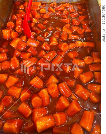 Spicy Korean tteokbokki with chewy rice cakes in a vibrant red sauce, topped with sesame seeds and green onions. A popular street food known for its addictive flavor and satisfying texture. Spicy Korean tteokbokki with chewy rice cakes in a vibrant red sauce, topped with sesame seeds and green onions. A popular street food known for its addictive flavor and satisfying texture. 131364596
